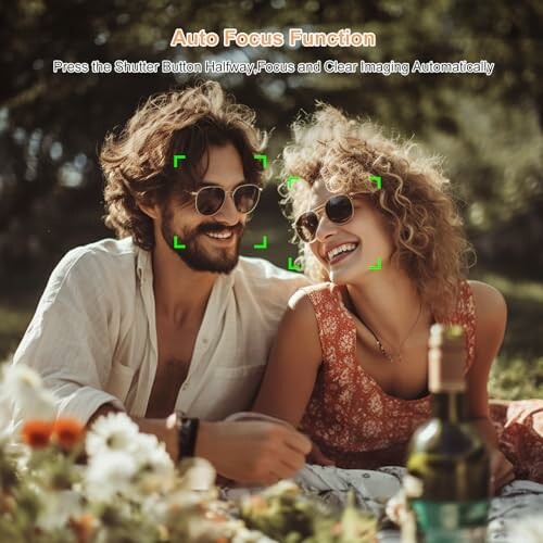 Smiling couple with sunglasses having a picnic outdoors.